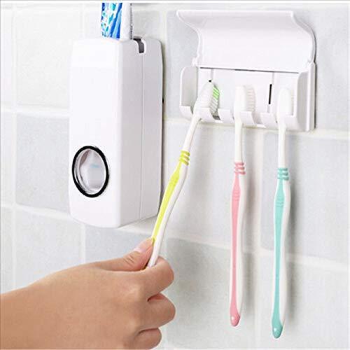 A hand places a toothbrush into the Wukusy 174 Toothpaste Dispenser Tooth Brush Holder, wall-mounted beside an automatic dispenser on a tiled bathroom wall. Two other toothbrushes are already in the holder.